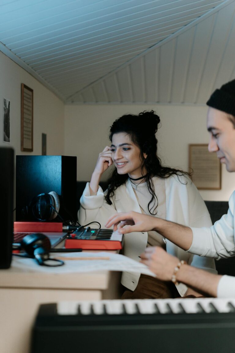 Two musicians enjoying a creative music production session in a home studio.