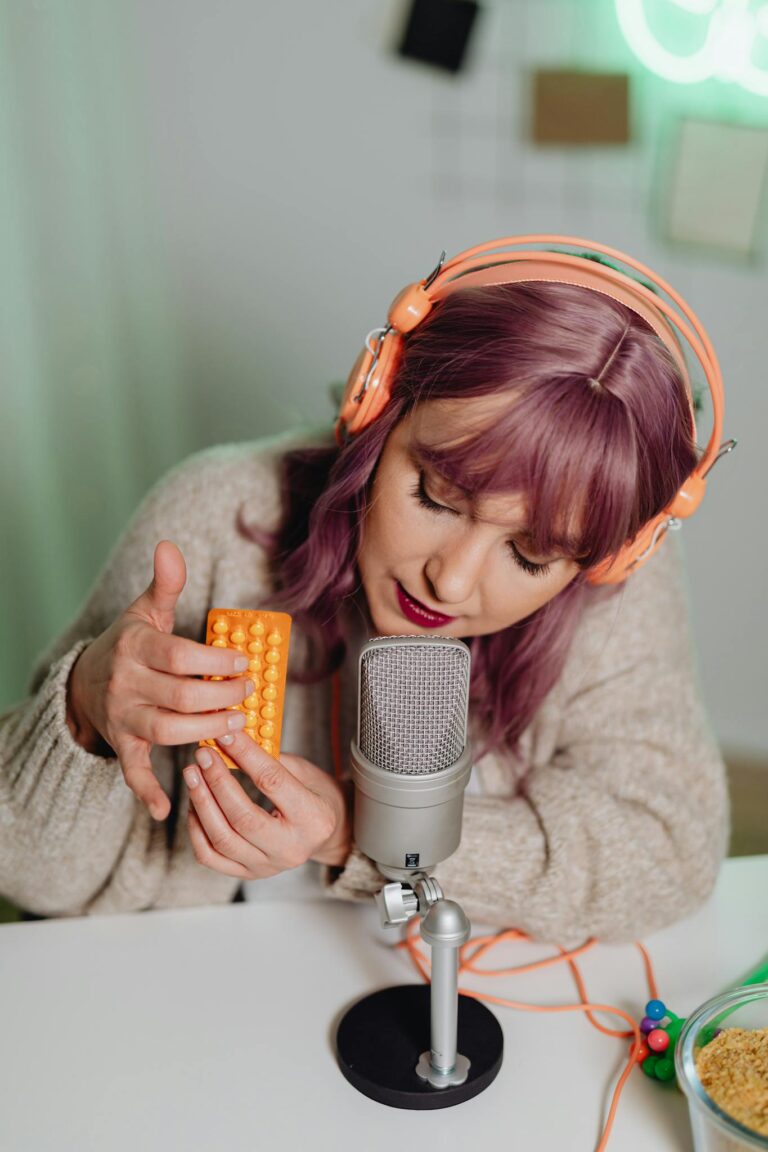 Woman wearing headset recording ASMR video with microphone and toy.